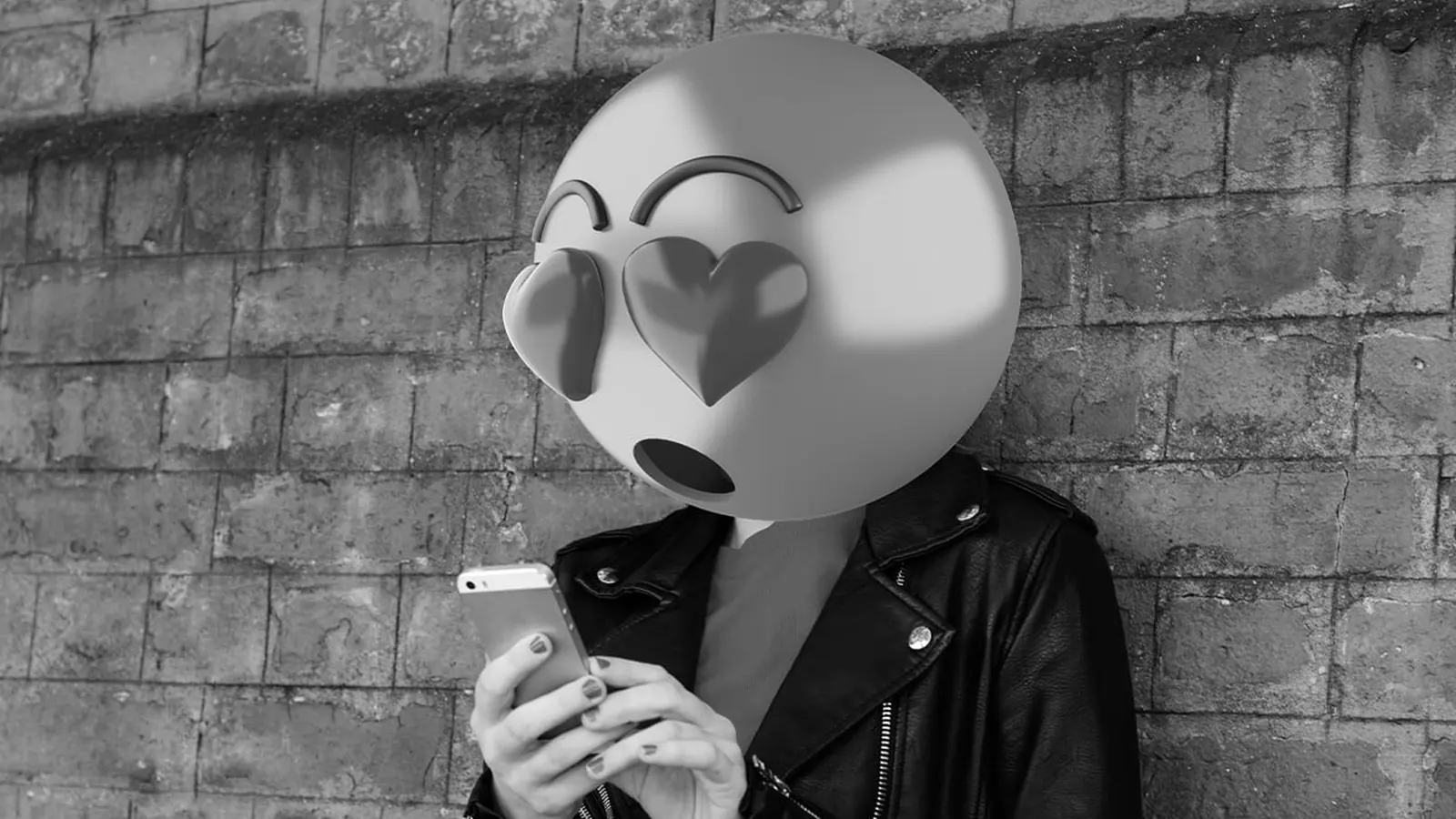 Person holding a phone with a heart-eyes emoji face, representing emotional signals and potential misinterpretation in digital communication