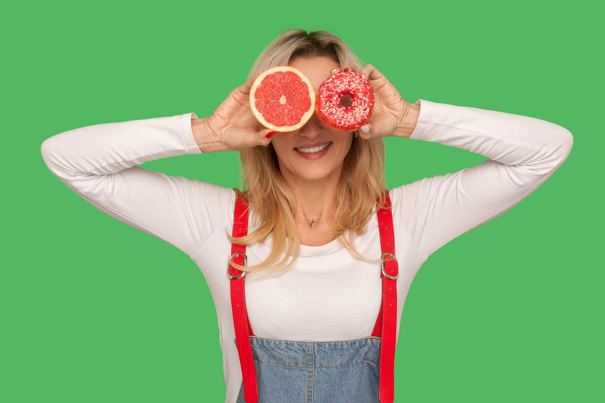 a women holding grapefruit and a doughnut
