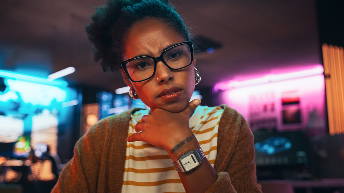 Woman looking thoughtfully at a computer, symbolizing how users seek deeper, AI-powered answers.