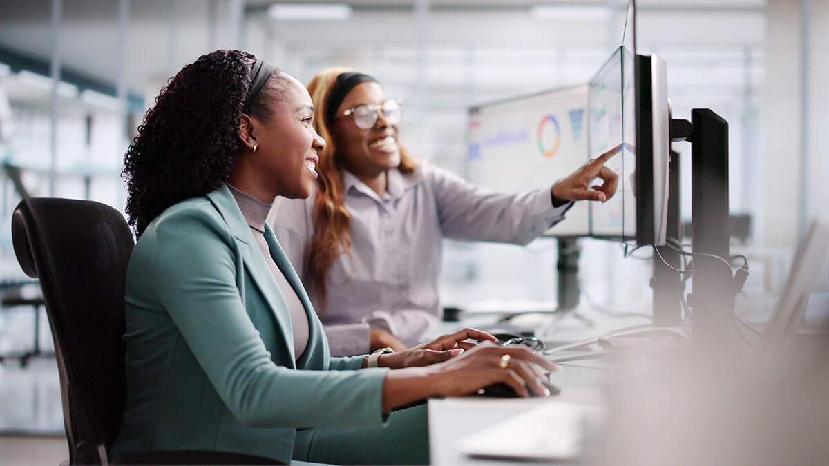 Female analyst using multiple screens for business data analysis.